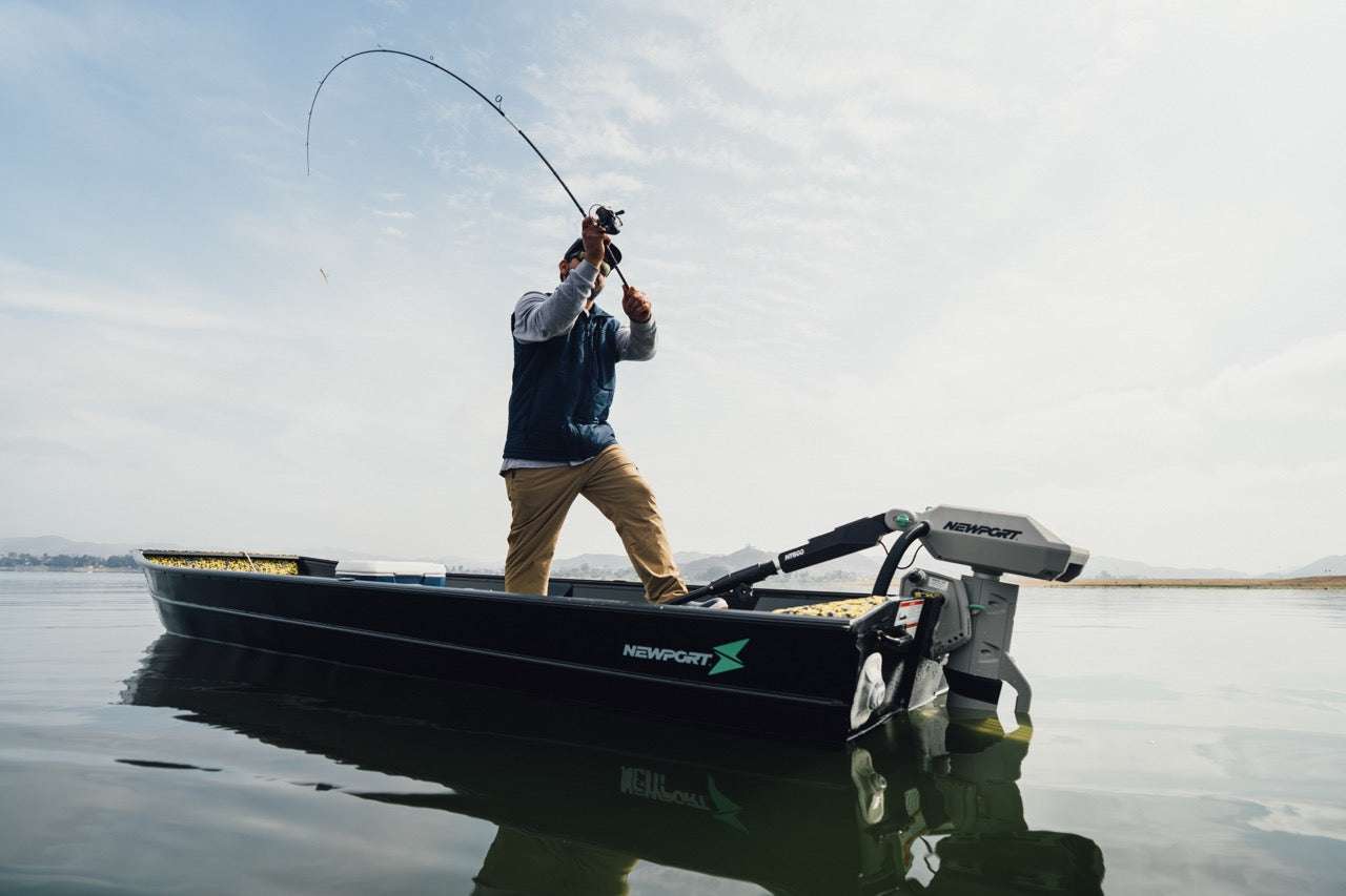 An angler makes a precise cast to boiling striped bass in the Northeast on a calm Chesapeake Bay Morning